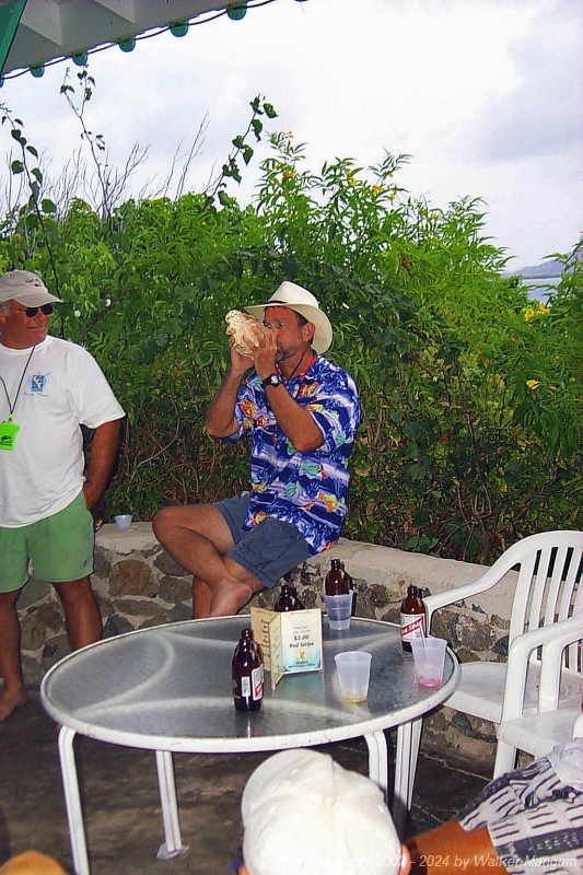 Walker showing the other contestants in the conch shell blowing contest at the 