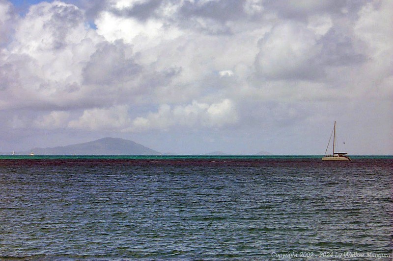 A catamaran approaching Anegada. The skipper of this catamaran was apparently navigationally challenged, as there is a prominent reef just ahead of him that is preventing him from reaching the beach. We first spotted this catamaran sailing north beyond the west end of Anegada, and knew that he had missed the island. He then turned and attempted to approach the island by motoring southeast, directly toward the reef, as shown in this photo. You can see two people up on the bows looking for reef. The reef is visible near the center of this photo, where small waves are breaking. When Walker saw this, he began taking photos to capture the event.

 
06/11/02 10:09 AM 
