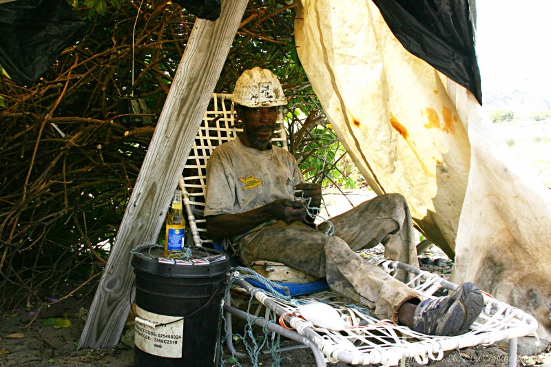 Henry, Salt Island's sole worker. Henry makes the charcoal and gathers the salt.

There is no electricity on Salt Island.  We just gave him the packages batteries sitting in front of the beer for his only entertainment - his transistor radio. Since there is also no refrigeration, we also broght him the cold Carib.