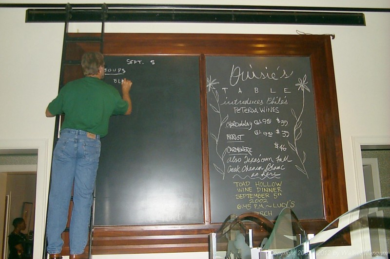 Walker writes the blackboard menu at Ouisie's.